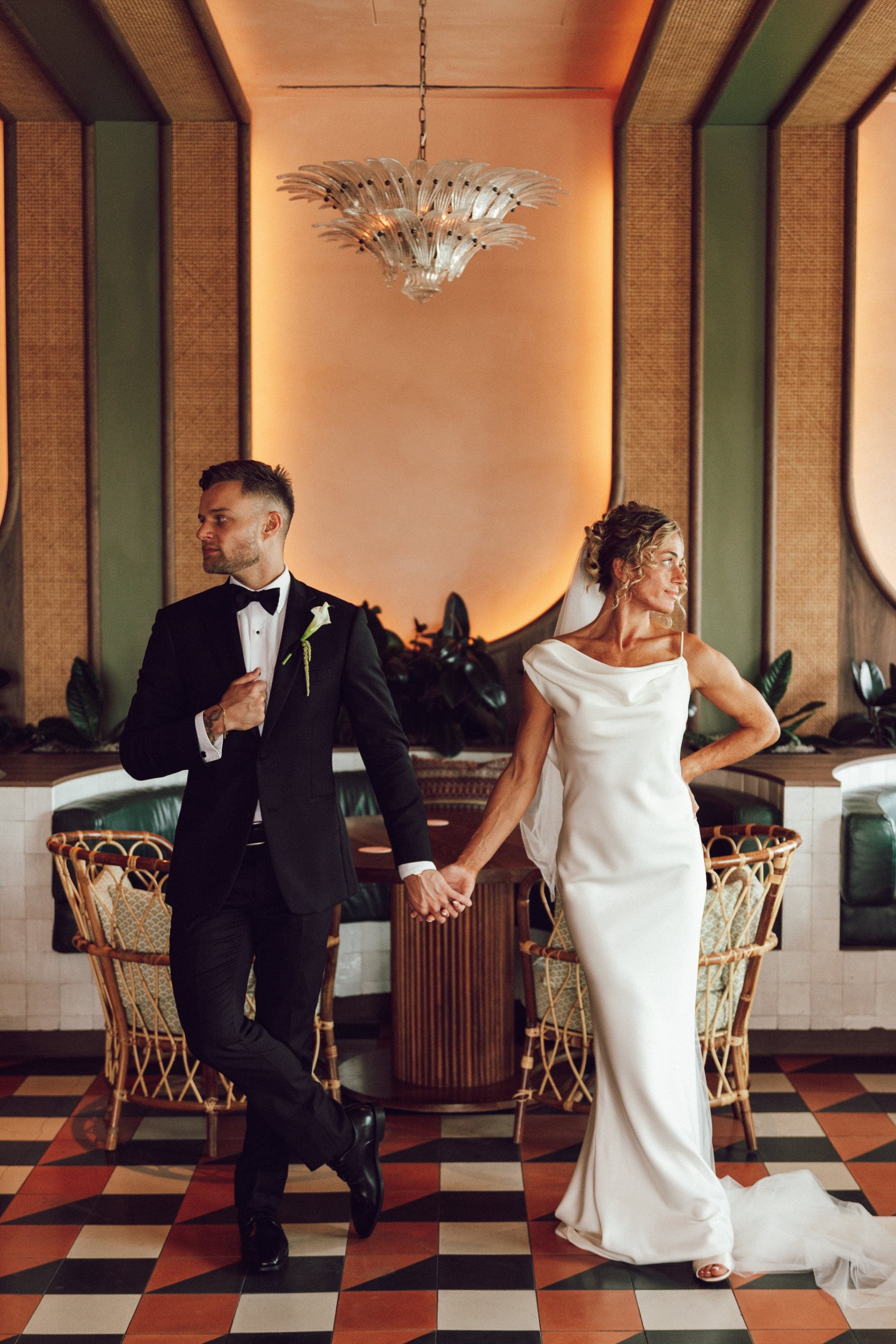 Couple holding hands across a tiled art deco room