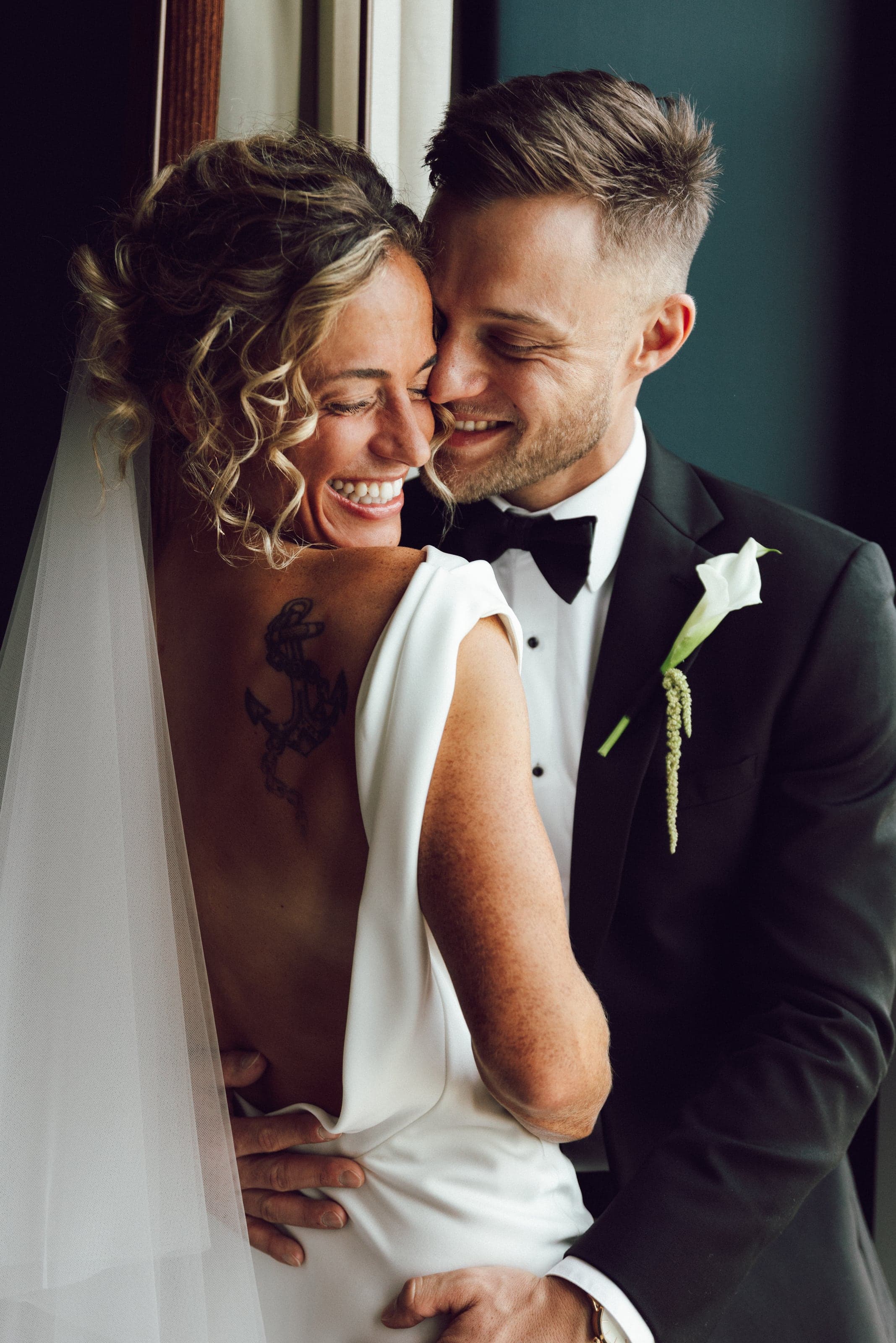 Bride resting her head on the groom’s shoulder, both smiling